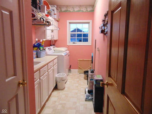 clothes washing area featuring cabinets and washing machine and dryer