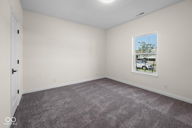 spare room featuring baseboards, visible vents, and carpet flooring