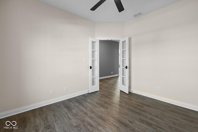 unfurnished room with dark wood-type flooring, visible vents, ceiling fan, and baseboards