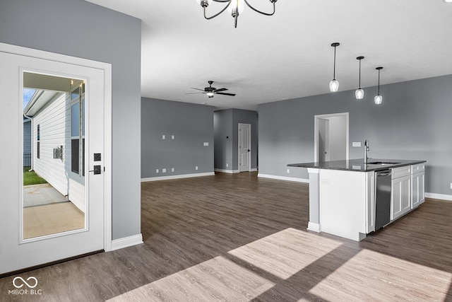 kitchen with baseboards, white cabinets, dark wood-style floors, dark countertops, and pendant lighting