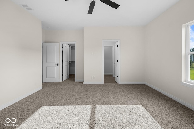 unfurnished bedroom featuring carpet, multiple windows, visible vents, and baseboards