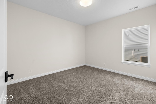 empty room with carpet floors, visible vents, and baseboards