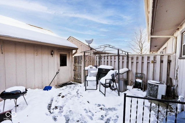 snow covered patio featuring cooling unit