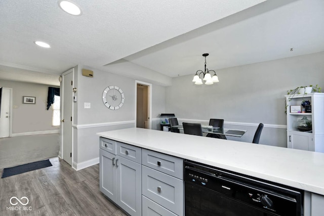 kitchen with hardwood / wood-style flooring, gray cabinetry, dishwasher, a chandelier, and pendant lighting