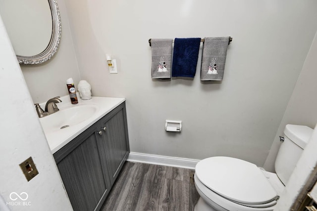 bathroom featuring toilet, wood-type flooring, and vanity