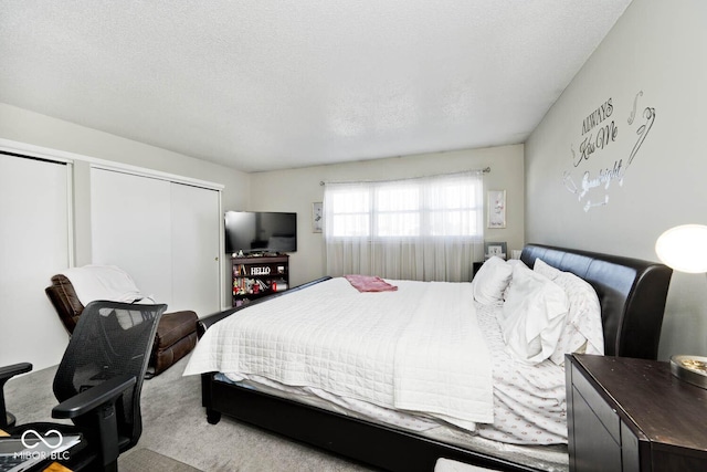 bedroom with a textured ceiling and light colored carpet