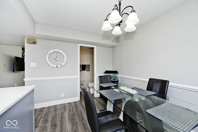 dining space featuring dark hardwood / wood-style floors and an inviting chandelier