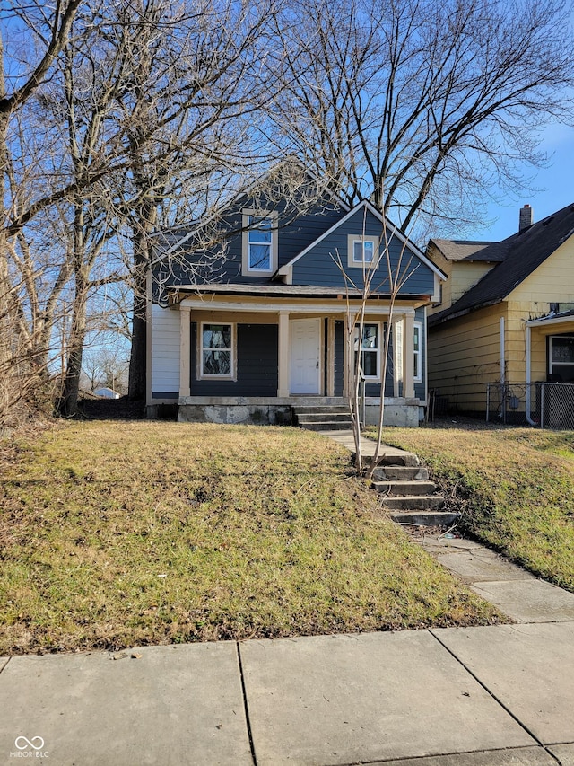 view of front of house featuring covered porch and a front yard