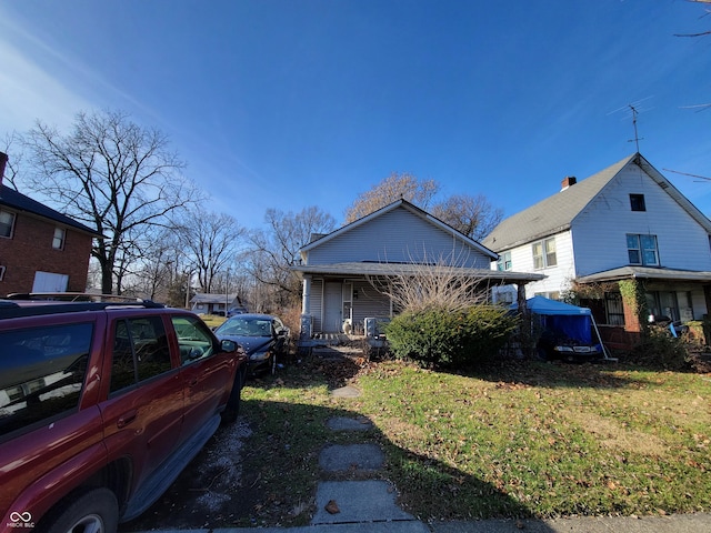 view of side of property with a porch and a yard