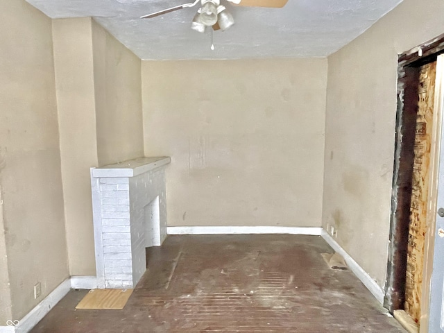 interior space with a brick fireplace and ceiling fan