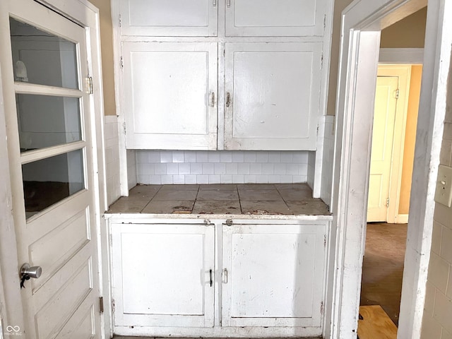 kitchen featuring backsplash, white cabinets, and tile countertops