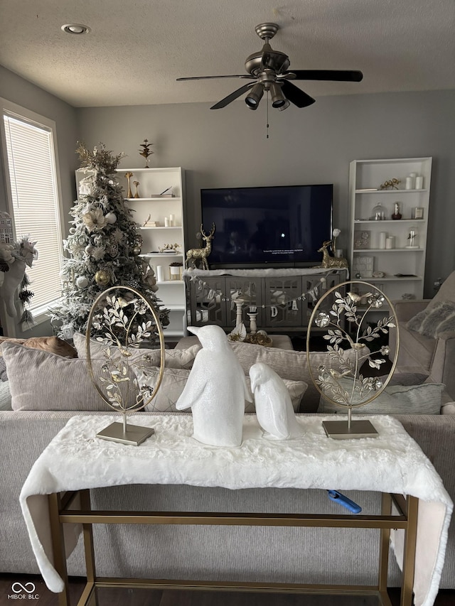 living room with ceiling fan and a textured ceiling