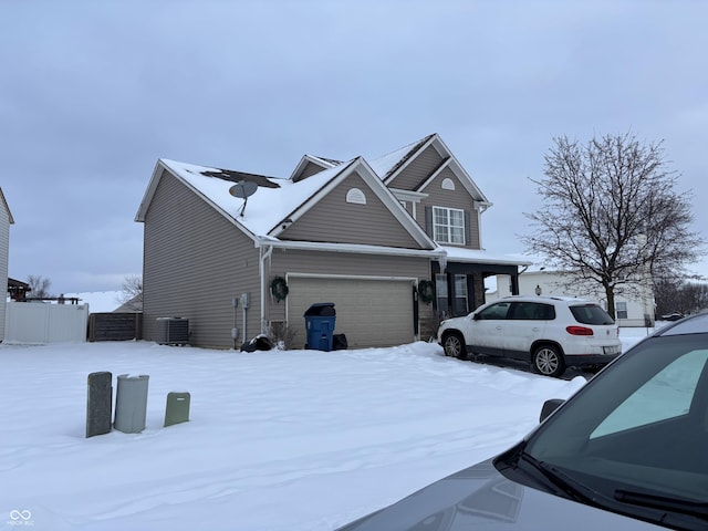 exterior space with central air condition unit and a garage