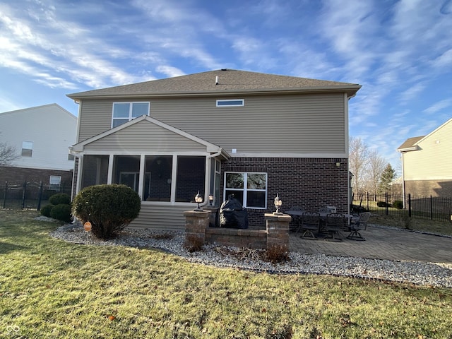 rear view of house featuring a sunroom, a yard, and a patio