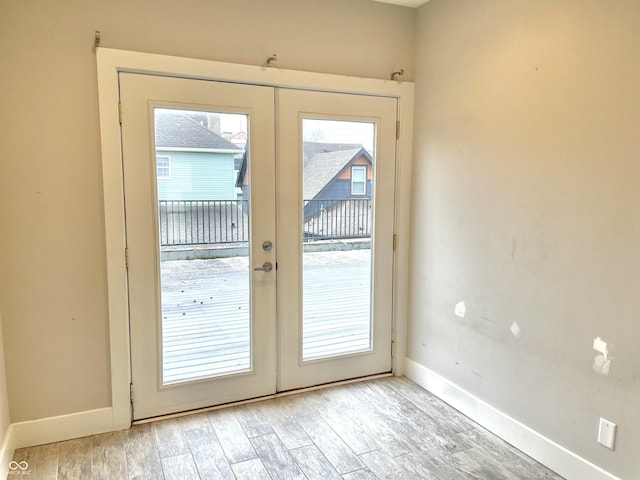 entryway with a healthy amount of sunlight, light hardwood / wood-style flooring, and french doors