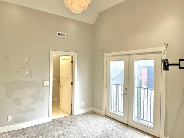 doorway to outside featuring light colored carpet, lofted ceiling, and french doors