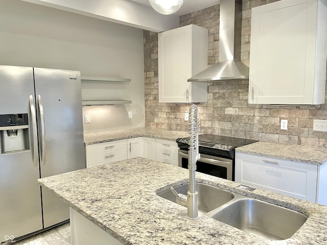 kitchen featuring appliances with stainless steel finishes, wall chimney exhaust hood, white cabinetry, and light stone counters