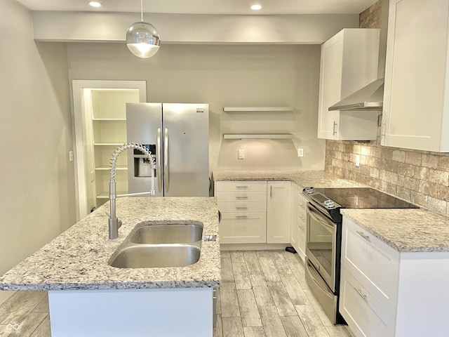 kitchen featuring an island with sink, sink, light stone counters, and stainless steel appliances