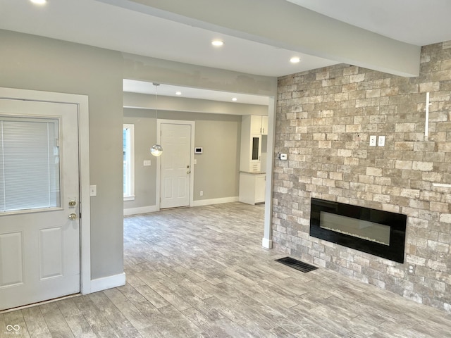 interior space with a large fireplace and light hardwood / wood-style flooring