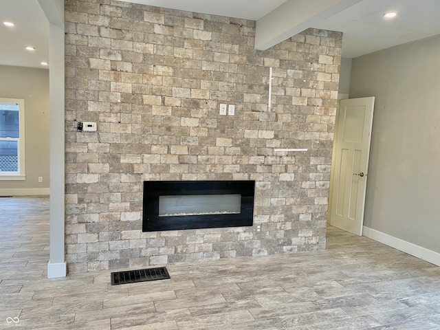 details featuring a large fireplace and beam ceiling