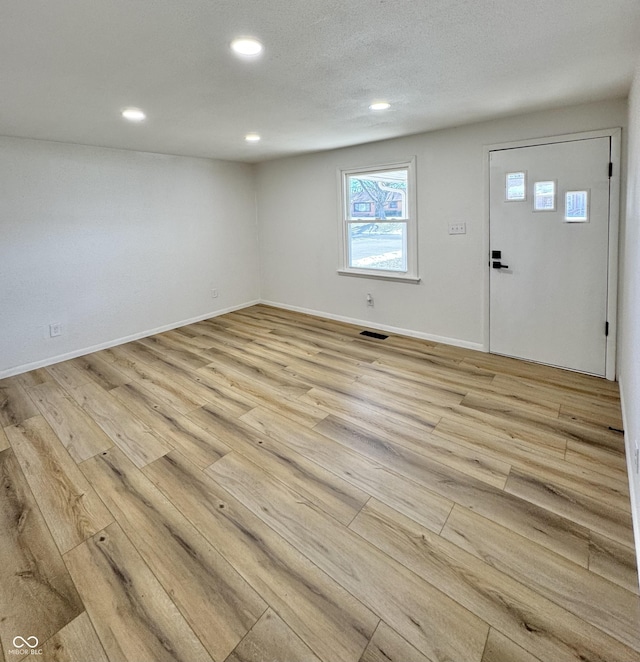 entryway featuring light hardwood / wood-style flooring and a textured ceiling