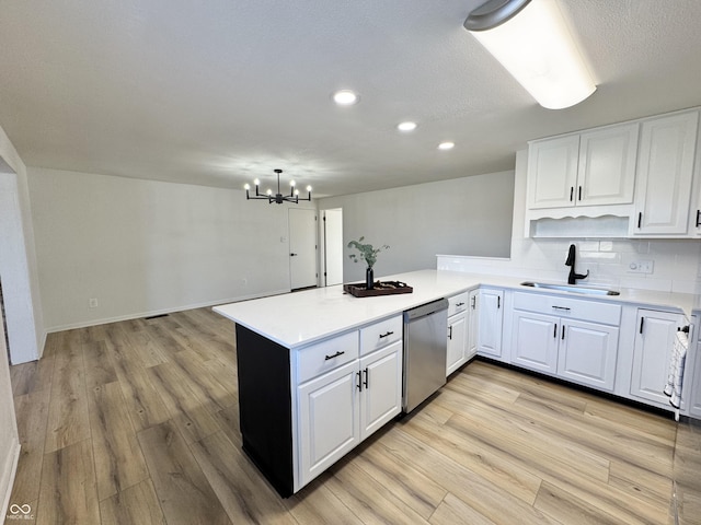 kitchen featuring tasteful backsplash, white cabinetry, dishwasher, sink, and kitchen peninsula