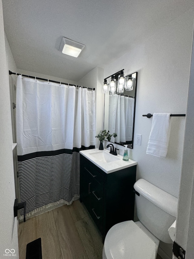 bathroom featuring vanity, hardwood / wood-style floors, toilet, and walk in shower