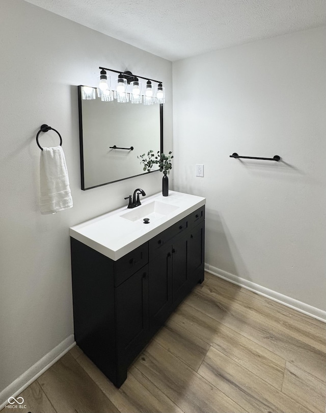 bathroom with vanity, hardwood / wood-style floors, and a textured ceiling