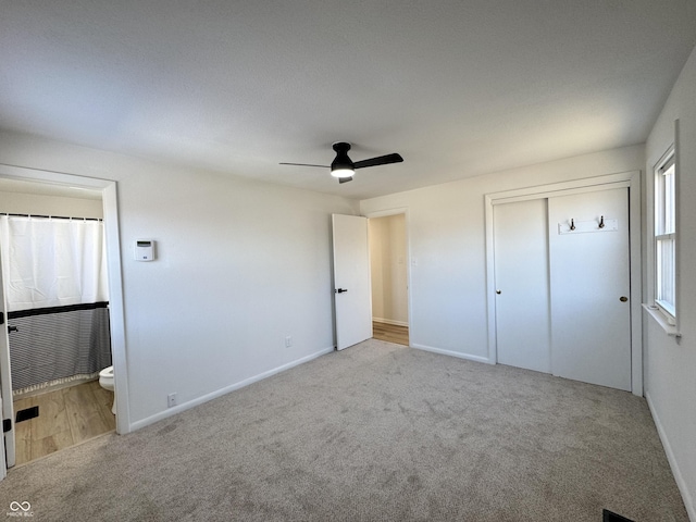 unfurnished bedroom with ensuite bathroom, light carpet, ceiling fan, and a closet