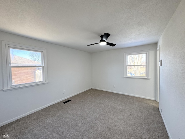 carpeted spare room with ceiling fan and a textured ceiling