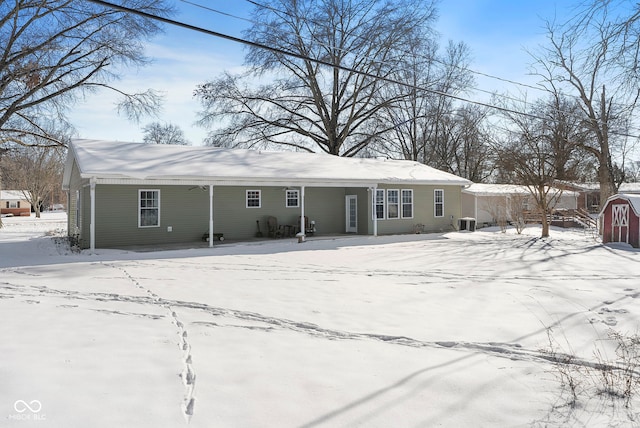 snow covered rear of property with cooling unit