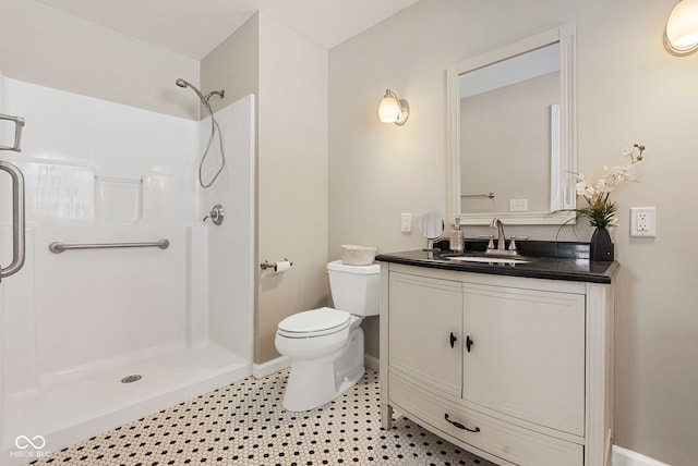 bathroom featuring a shower, vanity, and toilet