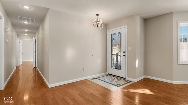 entryway featuring hardwood / wood-style floors and an inviting chandelier