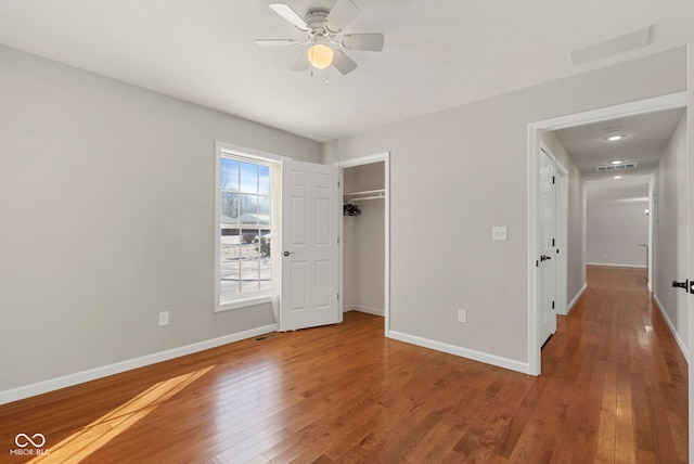 unfurnished bedroom with hardwood / wood-style floors, a closet, and ceiling fan