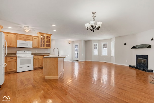 kitchen featuring light brown cabinets, light wood-type flooring, and white appliances