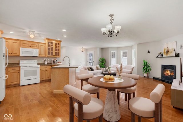 interior space featuring sink, light hardwood / wood-style floors, and ceiling fan with notable chandelier