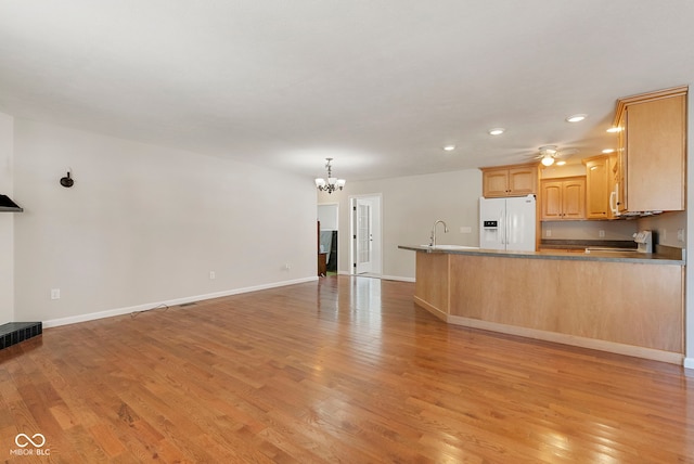 unfurnished living room featuring light wood-type flooring and an inviting chandelier