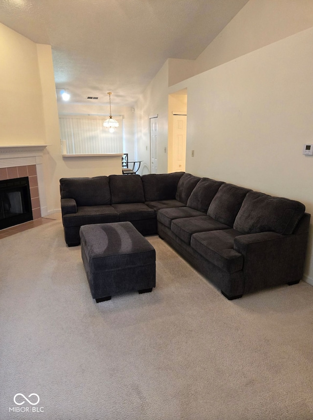 living room featuring a fireplace, carpet floors, an inviting chandelier, and vaulted ceiling