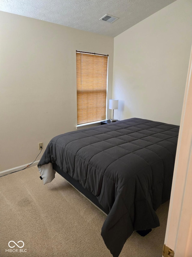 carpeted bedroom featuring a textured ceiling