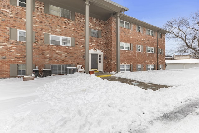 snow covered building featuring central air condition unit