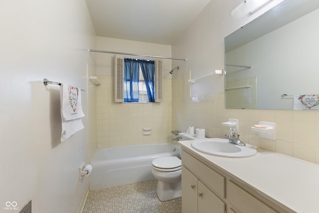 full bathroom with tile walls, vanity, tile patterned floors, toilet, and tiled shower / bath