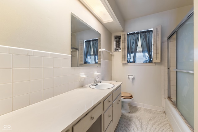 full bathroom with tile patterned flooring, vanity, bath / shower combo with glass door, and toilet