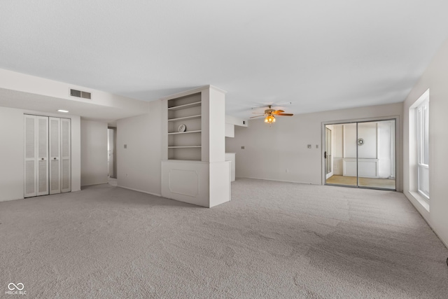 unfurnished living room featuring light carpet and ceiling fan