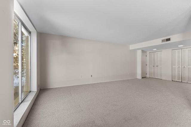 unfurnished room featuring light carpet