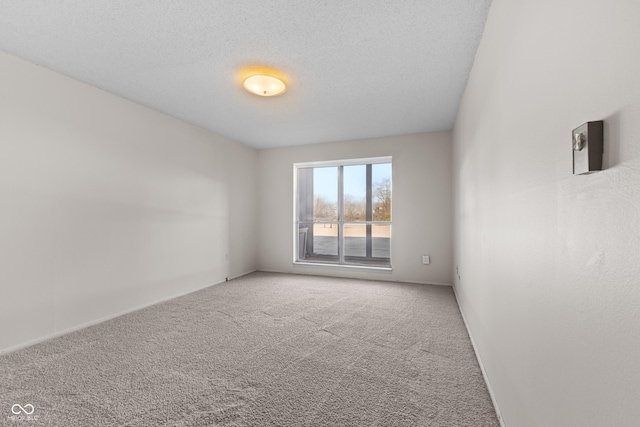 carpeted spare room featuring a textured ceiling