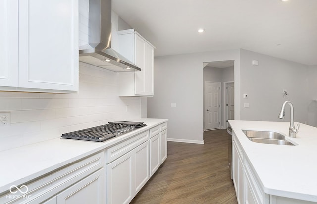 kitchen featuring white cabinetry, sink, wall chimney exhaust hood, stainless steel gas cooktop, and dark hardwood / wood-style floors