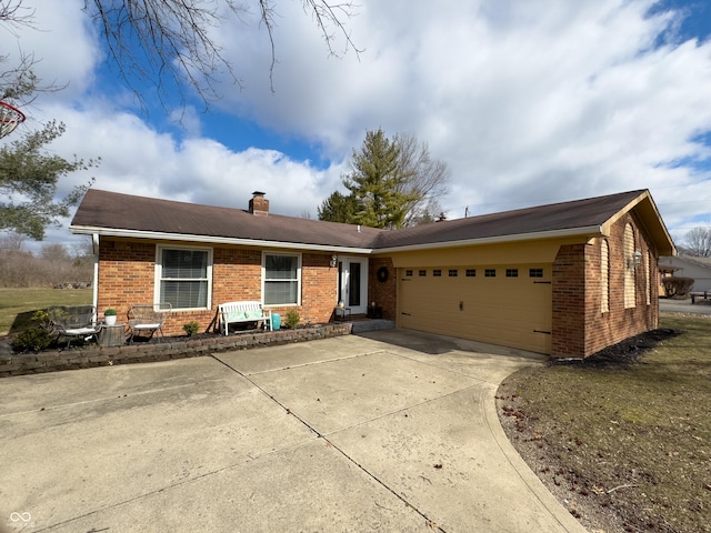 ranch-style home featuring an attached garage, a chimney, concrete driveway, and brick siding