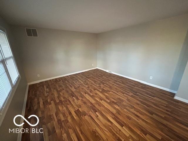 unfurnished room with dark hardwood / wood-style flooring