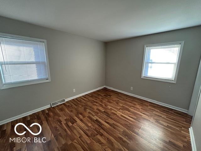 spare room with dark wood-type flooring