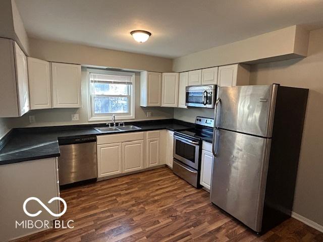 kitchen featuring white cabinets, dark hardwood / wood-style floors, sink, and appliances with stainless steel finishes